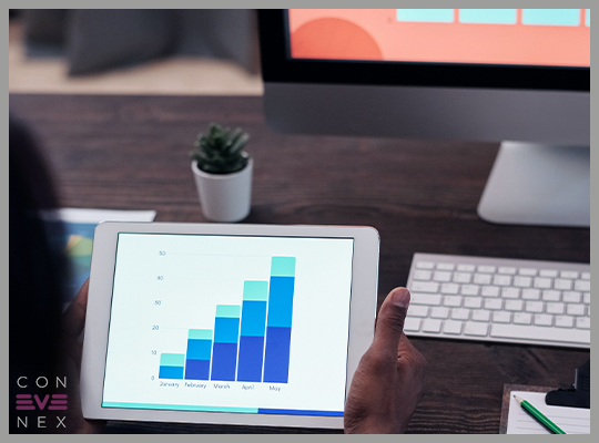 Blog | Dunkler Büro-Schreibtisch mit einem PC und IPad auf denen Umfrage-Auswertungen in Form von Diagrammen gezeigt werden
